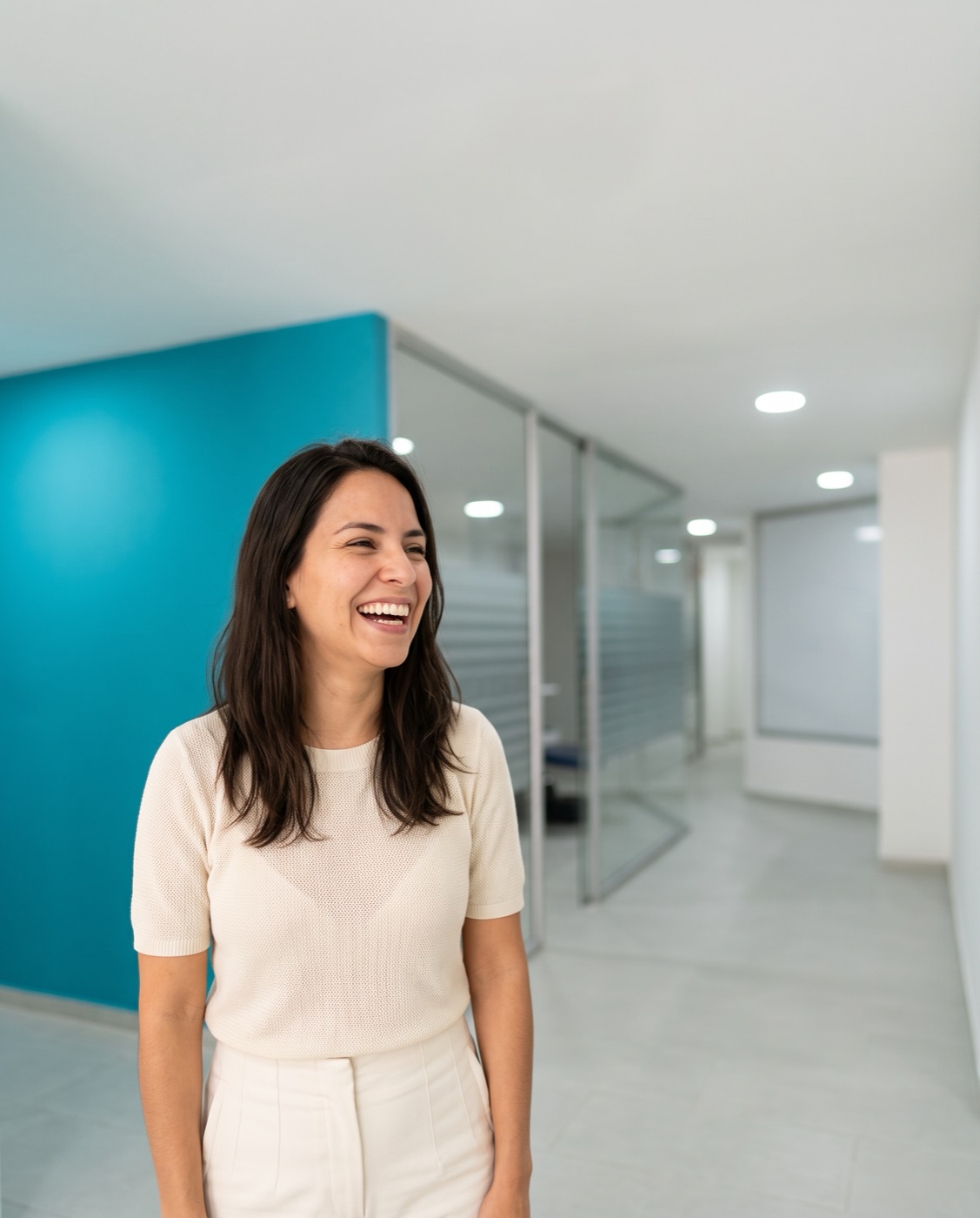 Paciente sonriendo en el pasillo de Omas Dental O+